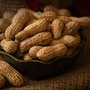 A rustic bowl filled with whole peanuts resting on a burlap cloth, evoking a natural and earthy feel.