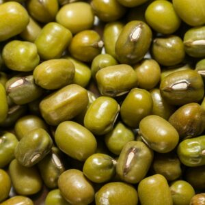 Macro photograph of fresh green mung beans, highlighting texture and color.